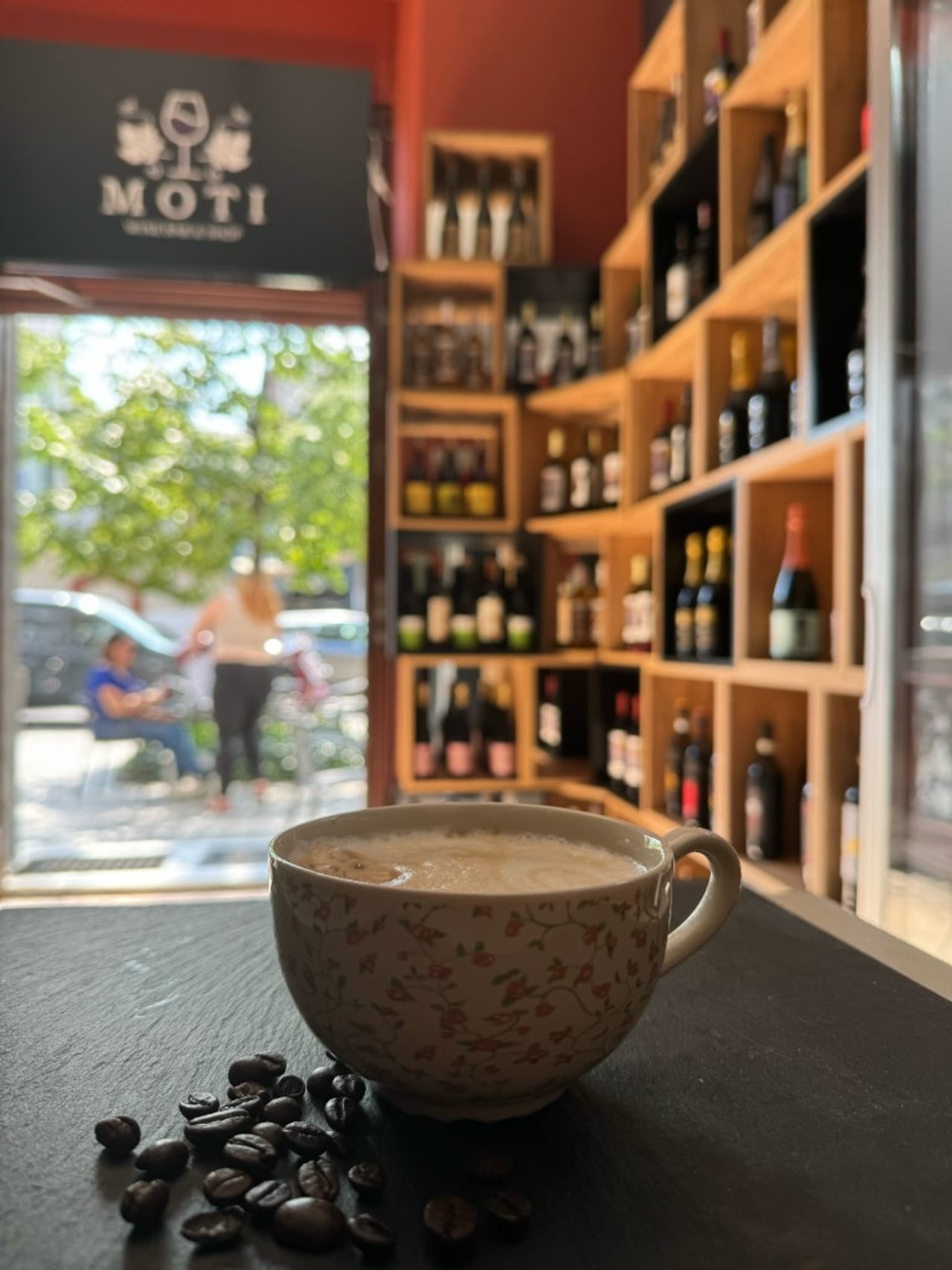 Kawa w Moti — w tle logo Wine Bar & Shop